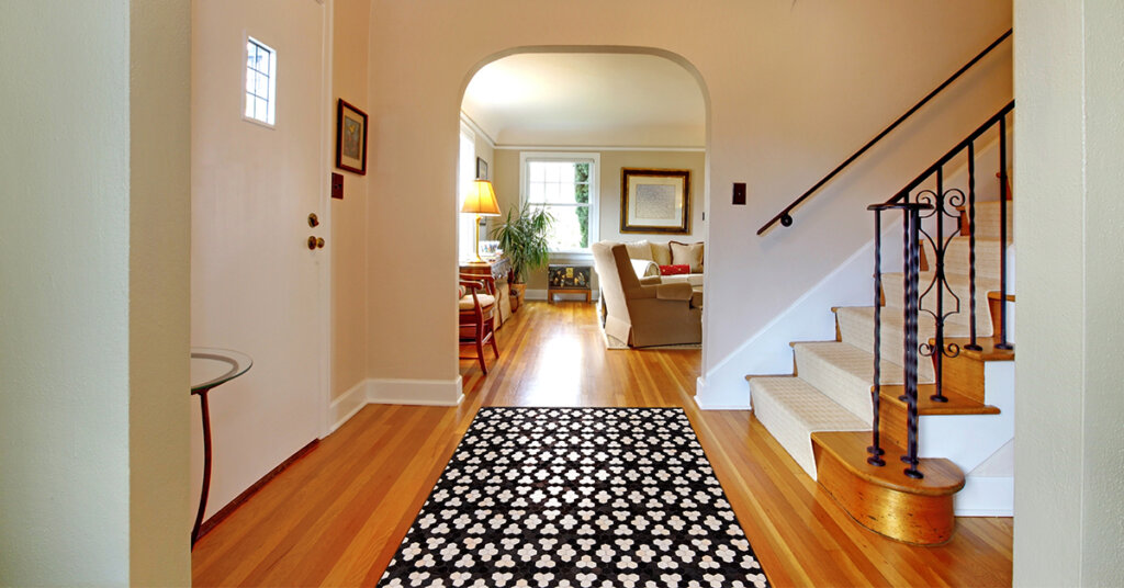 a foyer with a simple leather rug